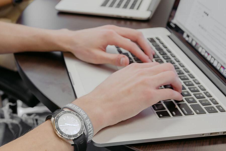 computer science student types on a keyboard.